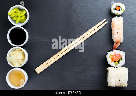 Typische asiatische Küche auf schwarze Küche Schiefer. Ingwer, Japanische Meerrettich Wasabi, Soja- und Fischsauce in kleinen weißen Schalen. Stäbchen. Sush Stockfoto