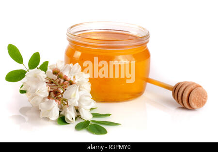 Krug Honig mit Blumen von Akazienholz auf weißem Hintergrund Stockfoto