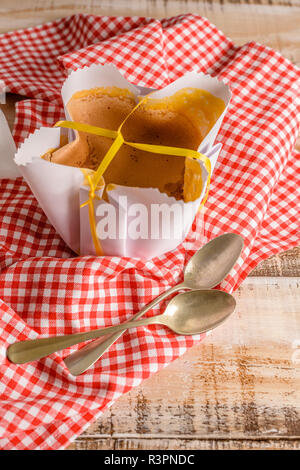 Portugiesische Biskuitboden in der typischen Papier auf den Backen verwendet verpackte, auf Holz- Hintergrund. Stockfoto