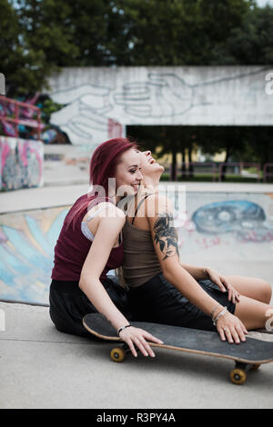 Gerne Freunde sitzen in Skatepark Stockfoto