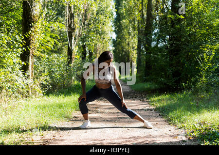 Weibliche Athleten Aufwärmen für Training in der Natur Stockfoto