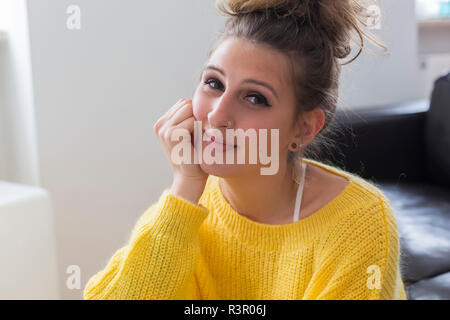 Portrait von lächelnden jungen Frau mit nasenpiercing tragen gelbe Pullover Stockfoto