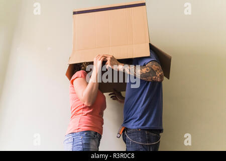 Paar mit Köpfe zusammen im Karton im neuen Zuhause Stockfoto