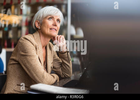 Senior Geschäftsfrau mit Tablette in ein Cafe denken Stockfoto