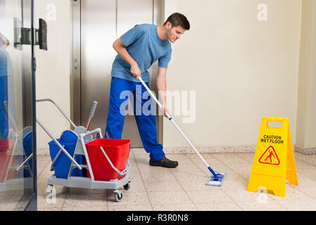 Männliche Hausmeister wischen Boden Stockfoto