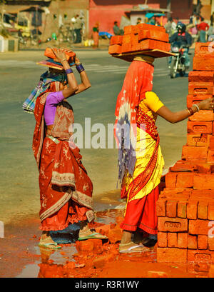 RAJASTHAN JAIPUR INDIEN JAIPUR ZWEI FRAUEN MIT SCHWEREN LASTEN VON HAUS ZIEGEL AUF DEN KOPF Stockfoto