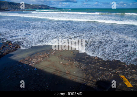 LAS PALMAS, Spanien - 23 NOVEMBER: Wasser ist aufgewühlt und voller Müll durch das Regenwasser ablaufen am Las Canteras Strand der Stadt nach einem Sturm auf Nov Stockfoto