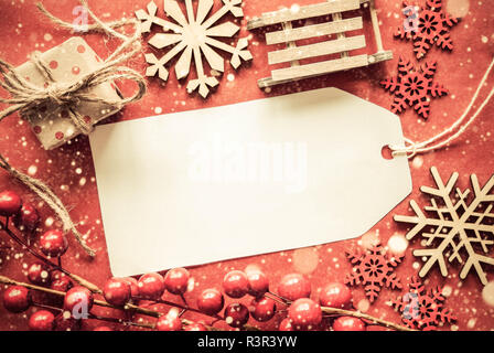 Etikett mit Sapce für Werbung kopieren. Flach mit leuchtend roten Weihnachten Dekoration wie Geschenk, Schlitten und Schneeflocken Stockfoto
