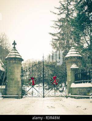 Alte vintage Cemetery gates Architektur mit Schnee und Weihnachten Kranz aus Forest Hills Cemetery in Boston Bereich Stockfoto