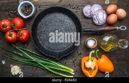 Konzept der kochen Rührei mit Tomaten, grüne Zwiebeln, Paprika und Gewürzen auf einem vintage Bratpfanne, um Lüge Zutaten, Ansicht von oben Stockfoto