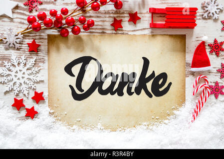 Helles Papier mit Deutschen Kalligraphie Danke, Danke. Weihnachtsdekoration wie Schlitten, Sterne, Schneeflocke und Santa Hut mit Schnee. Stockfoto