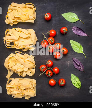 Gesunde Lebensmittel, Kochen und vegetarische Konzept Raw italienische Pasta mit Tomaten, Pilzen und Butter, ausgebreitet auf einem rustikalen Holzmöbeln Hintergrund Stockfoto