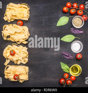 Gesunde Lebensmittel, Kochen und vegetarische Konzept Raw italienische Pasta mit Tomaten, Pilzen und Butter, ausgebreitet auf einem rustikalen Holzmöbeln Hintergrund bo Stockfoto