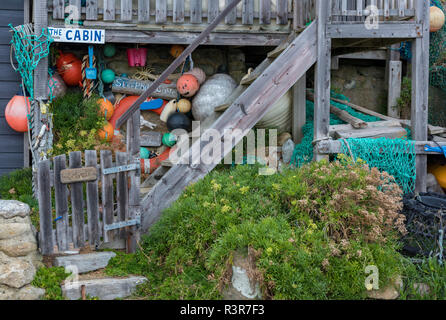 Alten bunten Fischen schwimmt und Strandgut außerhalb einer alten Hütte am steephill Fishermans Cove auf der Insel Wight. Stockfoto