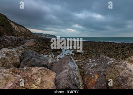 Die felsige und zerklüftete atmosphärischen Isle of Wight Küstenlinie bei steephill Cove in der Nähe von Ventnor auf der Insel. Felsstrand mit stürmischen Himmel und Rock Pools. Stockfoto