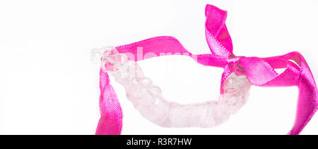 Isolierte transparente Zähne Prothese Ausrichter mit rosa Schleife so ein schönes Lächeln haben, Platz kopieren Stockfoto