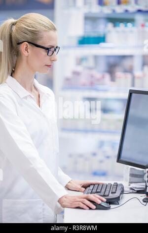 Weibliche Apotheker Arbeiten am Computer in der Apotheke. Stockfoto