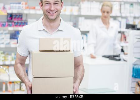 Kurier Kisten in der Apotheke mit Apotheker im Hintergrund. Stockfoto