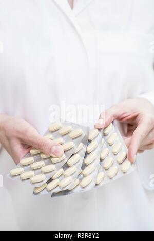 Nahaufnahme der Apotheker holding Tabletten in Blisterpackungen. Stockfoto