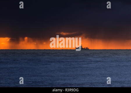 Ostsee mit einem Schiff am Horizont. dramatische Wolken am Horizont, um den Sonnenaufgang zu sehen. Wetter Phänomen Stockfoto