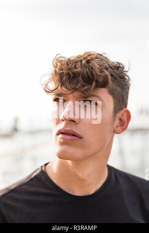 Portrait des jungen Mannes am Strand beobachten etwas Stockfoto