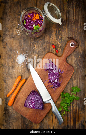 Hausgemachten Rotkohl, fermentiert, mit Chili, Karotte und Koriander, Einmachglas auf Holz Stockfoto