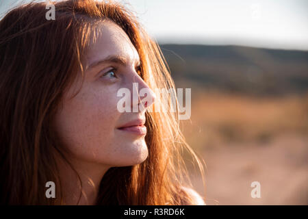 Lächelnde junge Frau mit Sommersprossen weg schauen Stockfoto