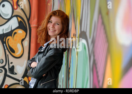 Italien, Finale Ligure, Portrait von lächelnden Teenager gegen Wandbild schiefen Stockfoto