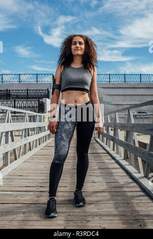 Junge athletische Frau stehend auf einem Pier Stockfoto