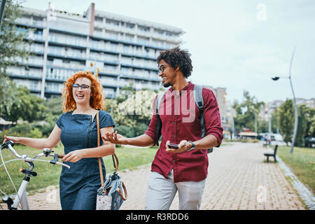 Freunde Wandern im Park, Reden, Frau, Fahrrad schieben Stockfoto