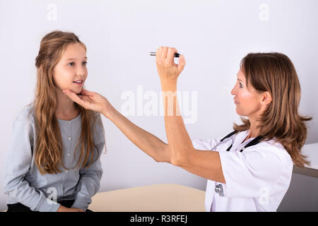 Reife Weibliche der Arzt, der die Untersuchung Mädchen Patienten Auge In der Klinik Stockfoto