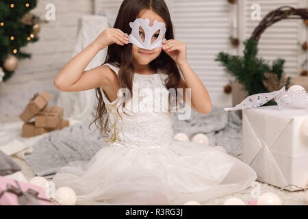 Kind Mädchen macht Papier Schneeflocken für Dekoration Weihnachtsbaum Stockfoto