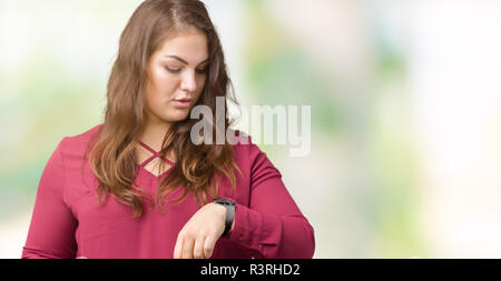 Schöne Übergrößen junge Frau über isolierte Hintergrund die Zeit kontrollieren, Armbanduhr, entspannt und zuversichtlich Stockfoto