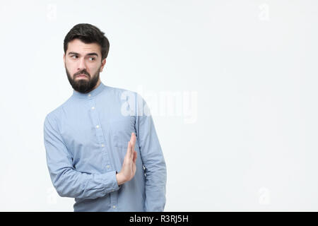 Attraktive spanische Mann mit Bart zeigt Ablehnung Geste, e, hat traurige Ausdruck Stockfoto