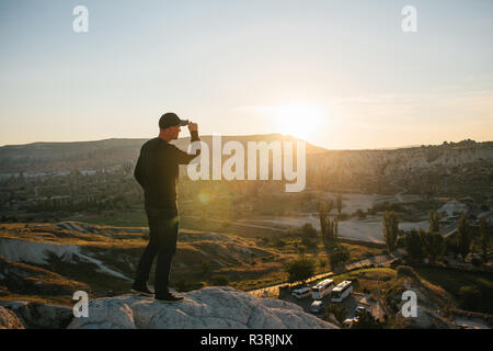 Ein Mann steht auf einem Berg in der Einsamkeit, bewundert die schöne Aussicht auf die Naturlandschaft in Kappadokien in der Türkei Stockfoto