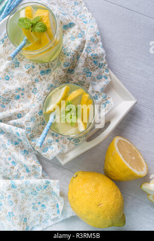 Sommer Zitrusfrüchte Drink auf Holz- Hintergrund. Detox citrus Flavored Water infundiert. Erfrischende Sommer hausgemachten Cocktail mit Zitrone. Frische Zitrone und Stockfoto