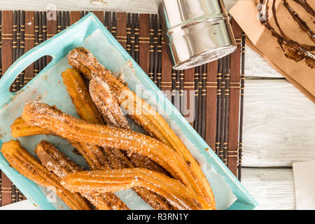 Traditionelle Churros mit heißer Schokolade Soße auf Holz- Zähler nach oben. Stockfoto