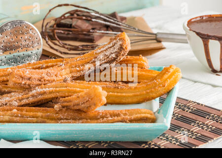 Traditionelle Churros mit heißer Schokolade Soße auf Holz- Zähler nach oben. Stockfoto