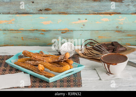 Traditionelle Churros mit heißer Schokolade Soße auf Holz- Zähler nach oben. Stockfoto