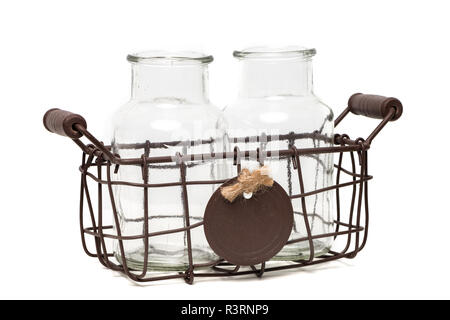 Zwei leere Glas bottless in einem vintage Drahtkorb auf weißem Hintergrund. Stockfoto