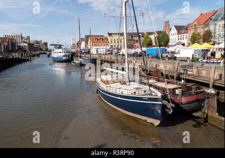 HUSUM, Deutschland - 16. SEPTEMBER 2018: Binnenhafen in Husum bei Ebbe, die Schiffe auf dem Wattenmeer liegen, während ein Markt für Touristen findet am Stockfoto