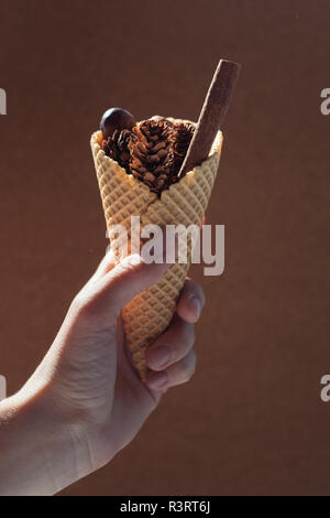 Woman's Hand hält Eistüte mit herbstlichen befüllen Stockfoto