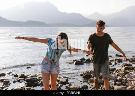Junges Paar Hand in Hand am See Stockfoto