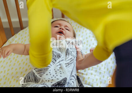 Mutter sie ihr Baby Mädchen vom Bett Stockfoto