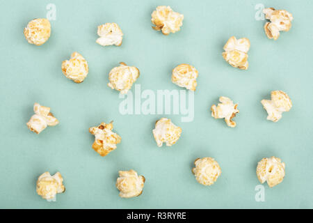 Popcorn auf grünem Hintergrund. Ansicht von oben. Flach Muster Stockfoto