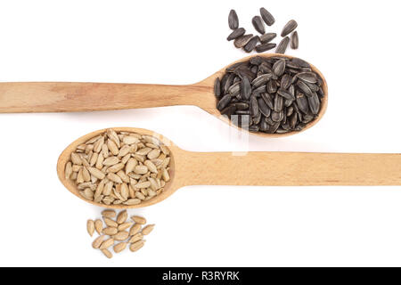 Geschälte und ungeschälte Körner in einem hölzernen Löffel auf weißem Hintergrund. Ansicht von oben Stockfoto