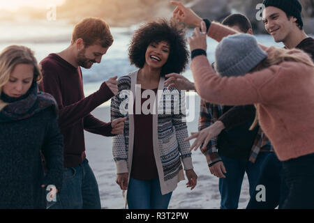 Glückliche junge Freunde feiern am Strand und tanzen. Multi-ethnischen Männer und Frauen, die Spaß am Strand Party. Stockfoto