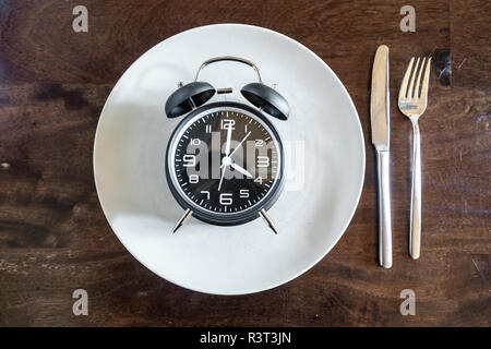 Intermittierendes fasten, Trend 16:8 anlegen, den Wecker auf Platte Stockfoto