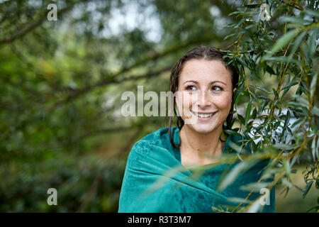 Portrait von Sommersprossige junge Frau mit nassem Gesicht und Haare eingewickelt in ein Handtuch Stockfoto