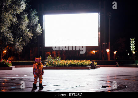 Spaceman auf einem Platz in der Nacht von strahlenden Projektionsfläche angezogen Stockfoto